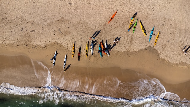 Kayaks lined up on beach - water sports equipment rentals available for booking