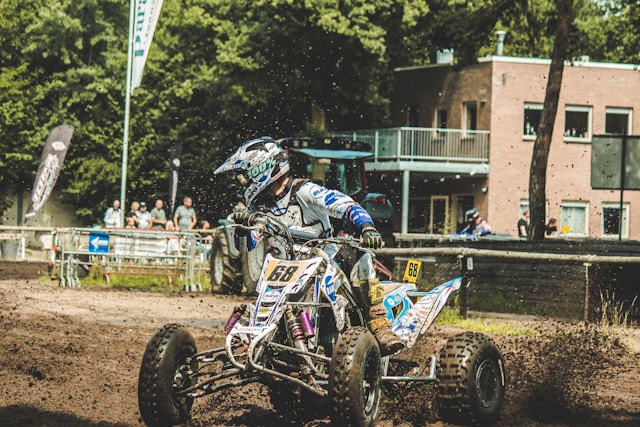 ATV quad bike racing through dirt terrain - adventure sports activity available for booking